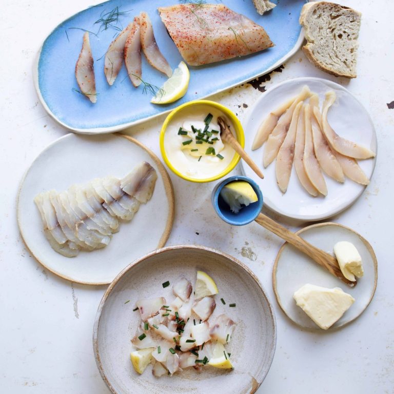 Assortiment de poisson, morceaux de pain, citron et sauces, présenté sur des assiettes. Assortiment de poisson, morceaux de pain, citron et sauces, présenté sur des assiettes.